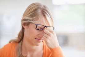 woman suffering headache in orange jumper
