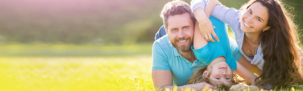 young family laying on the grass couple and child