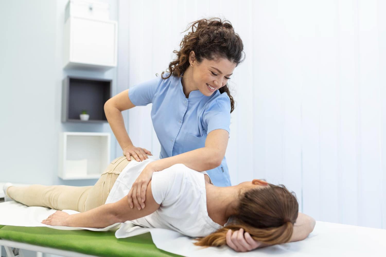 A physical therapist providing treatment to a patient on a massage table.